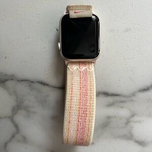 Apple Watch Series SE, with charger and Nike wristband.